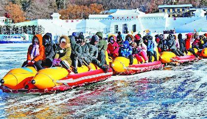 游客在牡丹江镜泊湖体验冰雪游玩项目